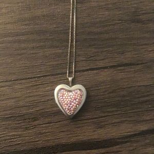 Silver locket with pink gems on it